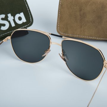 aviator style sunglasses on a white table with carrying case beside them